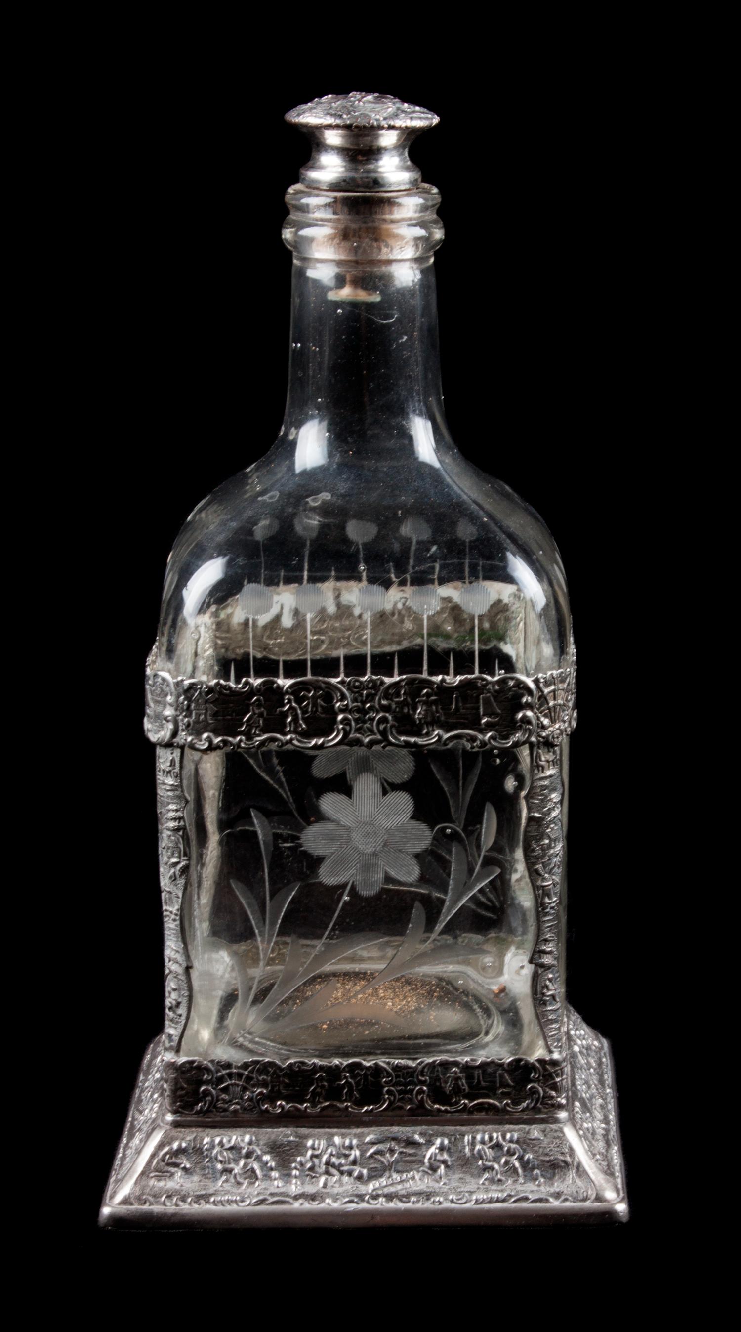 A Silver Mounted Glass Decanter, 19th Century, the silver worked with C-scrolls and figures, the decanter etched with floral decoration