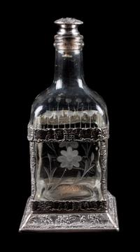 A Silver Mounted Glass Decanter, 19th Century, the silver worked with C-scrolls and figures, the decanter etched with floral decoration