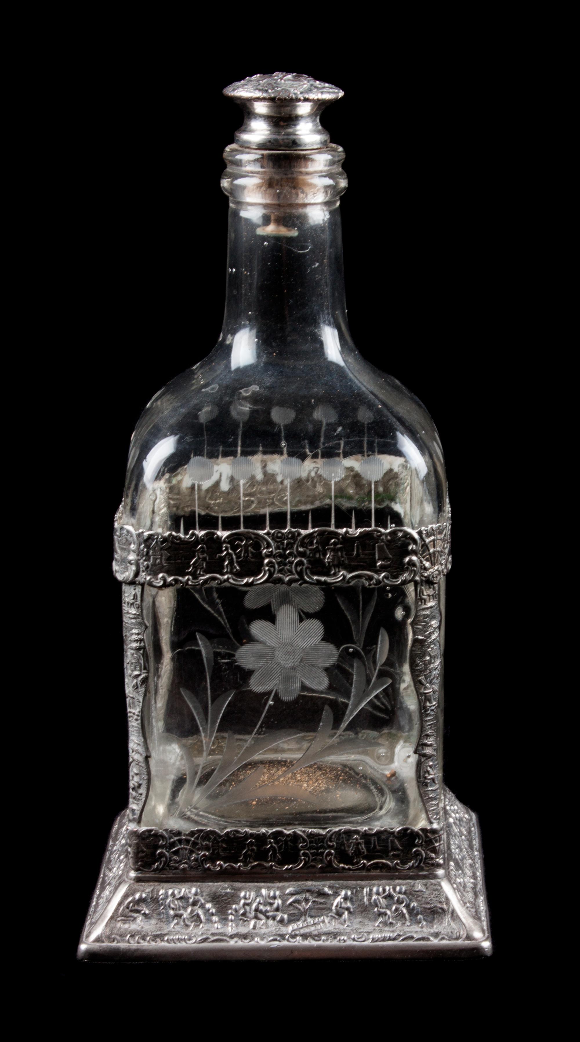 A Silver Mounted Glass Decanter, 19th Century, the silver worked with C-scrolls and figures, the decanter etched with floral decoration