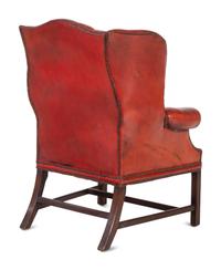 A Pair of Leather Wingback Armchairs with Ottoman