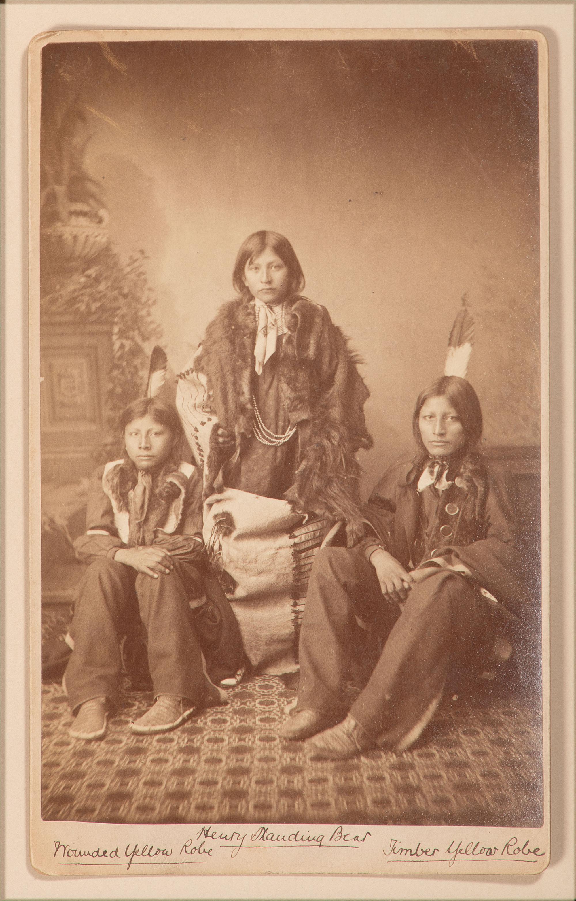 CHOATE, John N. (1848-1902), photographer. Boudoir card featuring a trio of Santee Sioux students of Carlisle Indian School, identified on mount as Henry Standing Bear, Wounded Yellow Robe, and Timber Yellow Robe. Carlisle, PA, ca 1883.