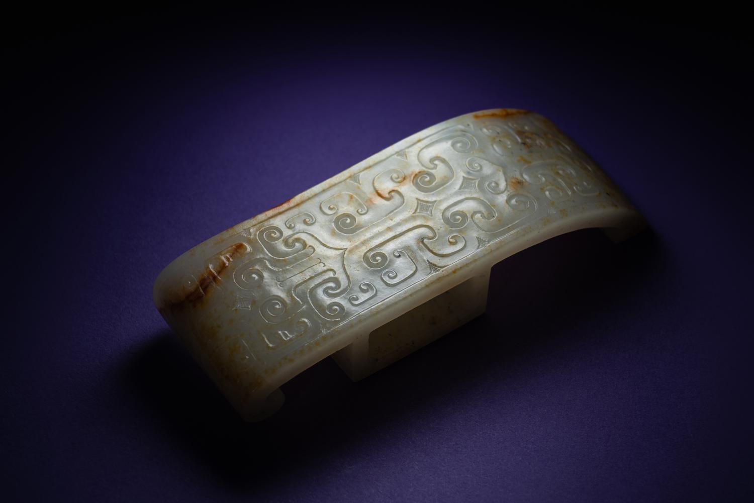 A Chinese White and Russet Jade Sword Slide, Jianzhi