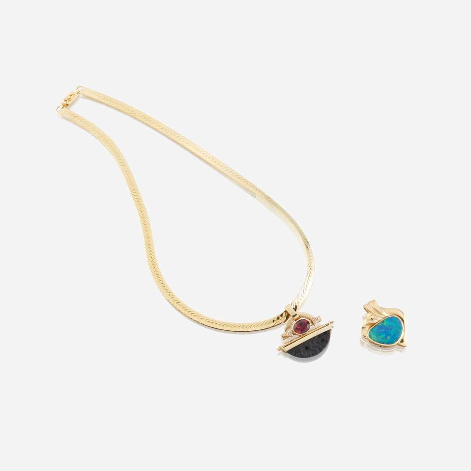 Two fourteen karat gold and gem-set enhancers with necklace