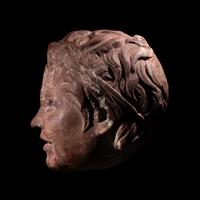A Roman Rosso Antico Head of a Young Satyr