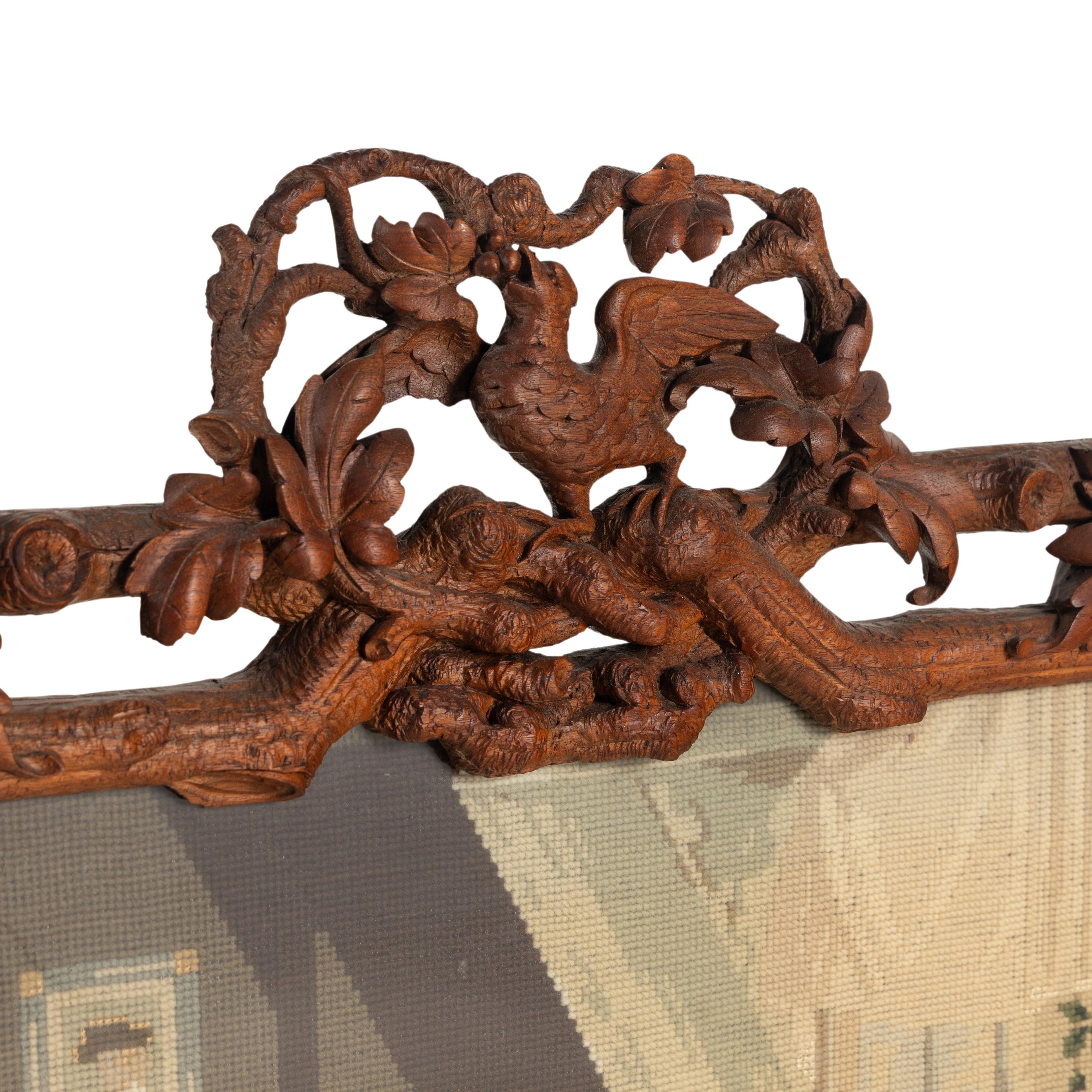 A Swiss "Black Forest" Carved Needlepoint-Inset Firescreen