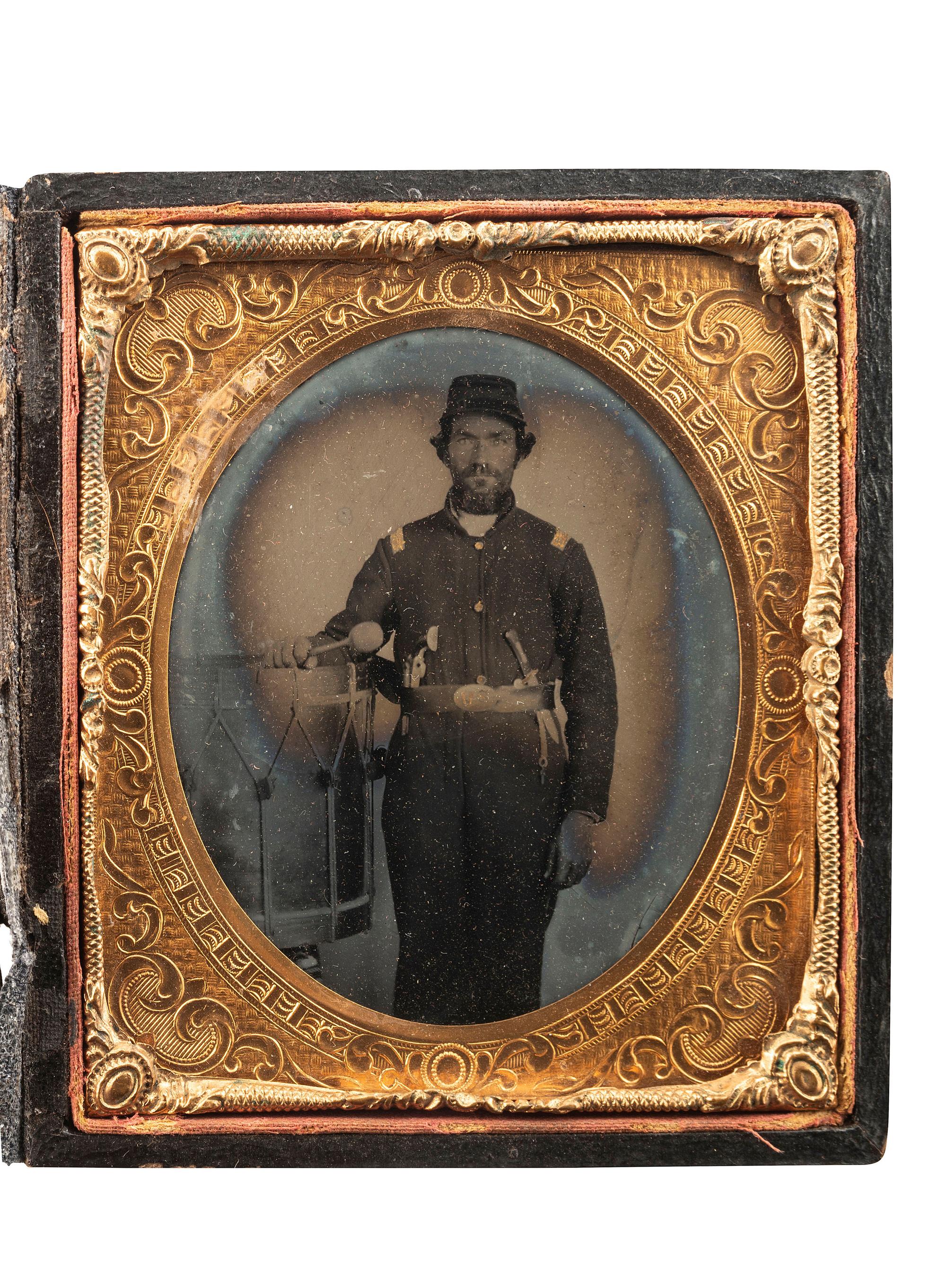 [CIVIL WAR]. Sixth plate ruby ambrotype of a double-armed Union bass drummer posed with his instrument.