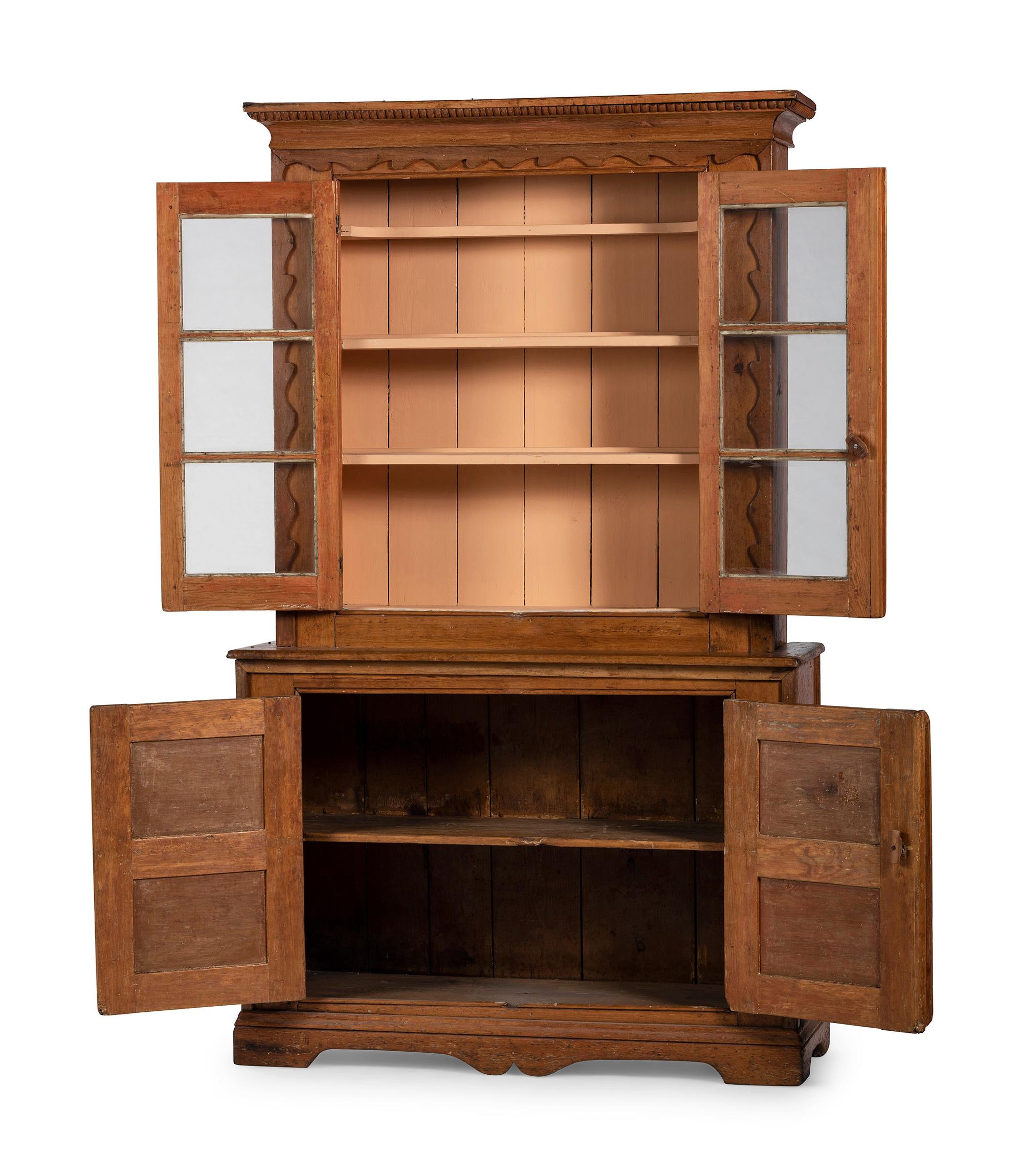 A Folk Art Carved and Paneled Pine Step-Back Cupboard