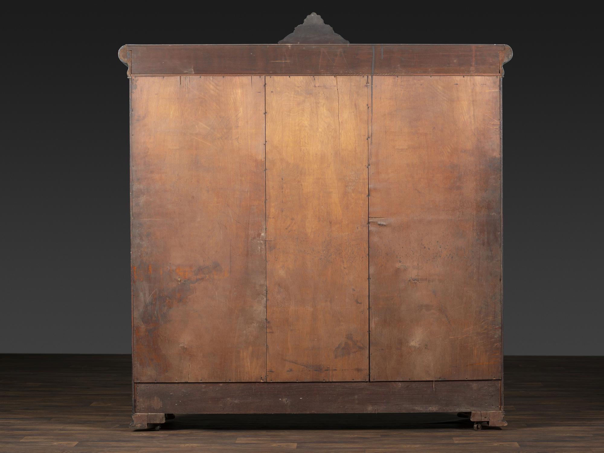 An Aesthetic Movement Crane and Mask Carved Mahogany and Glass Paneled Bookcase