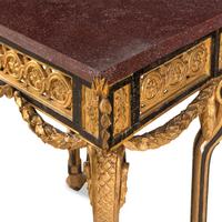 A Neoclassical Style Gilt Bronze Mounted Parcel-Gilt, Ebonized and Porphyry-Top Center Table