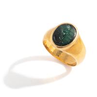A Roman Gold and Plasma Finger Ring with a Figure Holding Tools and an Inscription