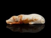 A White and Russet Jade Figure of a Recumbent Dog