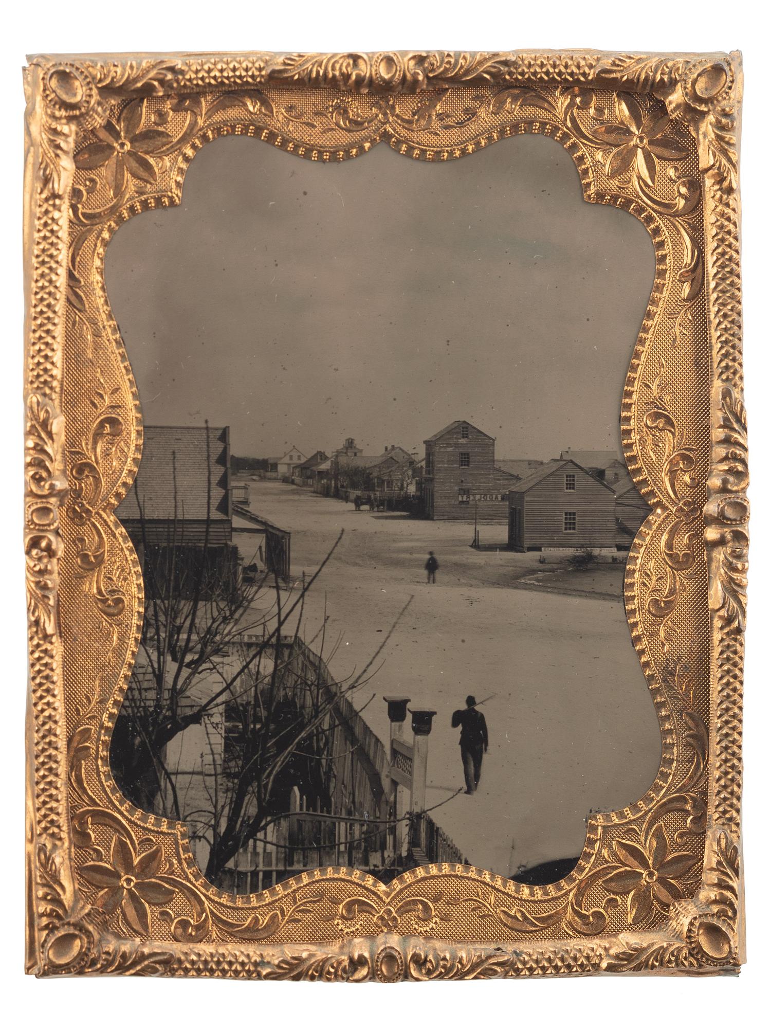 [CIVIL WAR]. Quarter plate tintype of a soldier walking down the street of a likely Carolina town, with sign for oyster saloon partly visible.