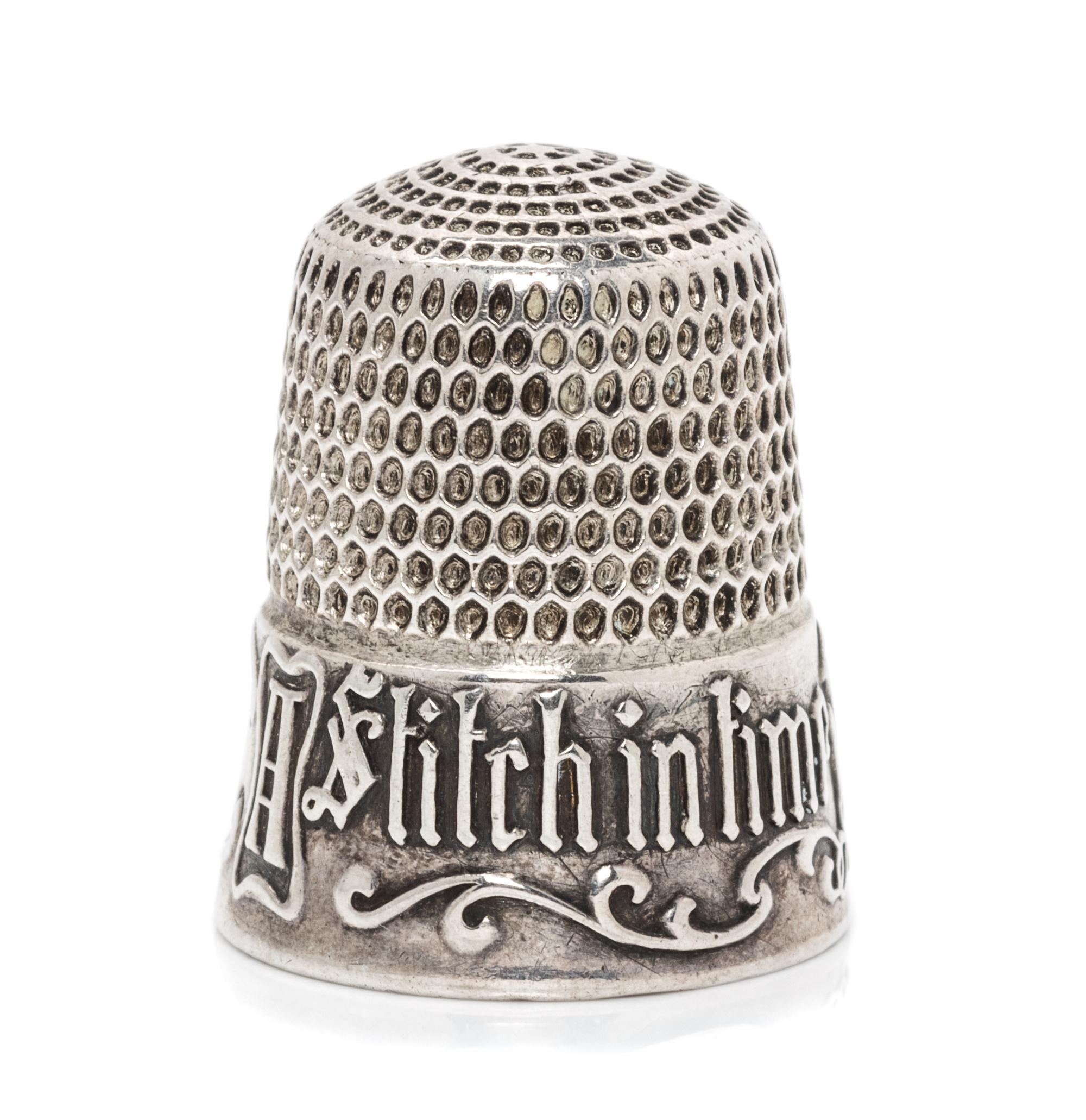 An American Silver Thimble, Simons Bros., Philadelphia, PA, the based marked A Stitch in Time Saves Nine with a vacant cartouche framed