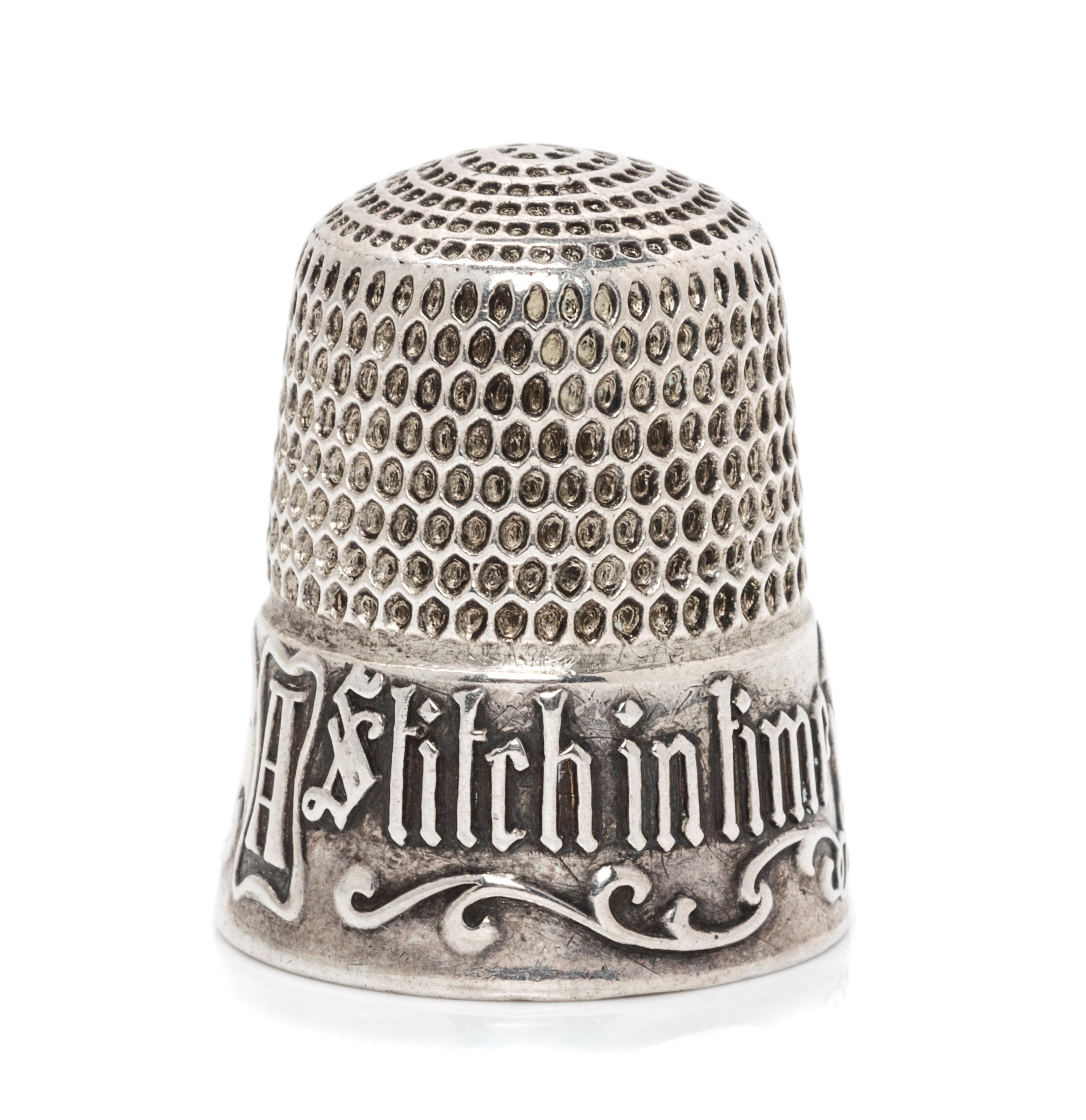 An American Silver Thimble, Simons Bros., Philadelphia, PA, the based marked A Stitch in Time Saves Nine with a vacant cartouche framed