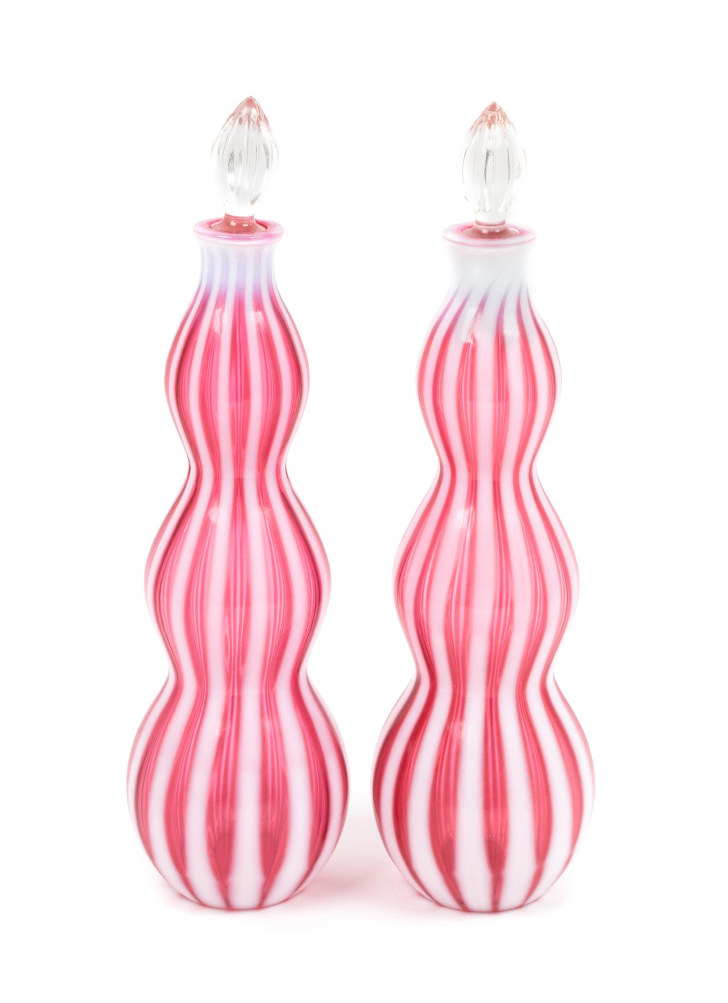 A Pair of Cranberry Rib Optic Bottles Height 14 1/4 inches.