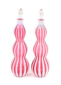 A Pair of Cranberry Rib Optic Bottles Height 14 1/4 inches.