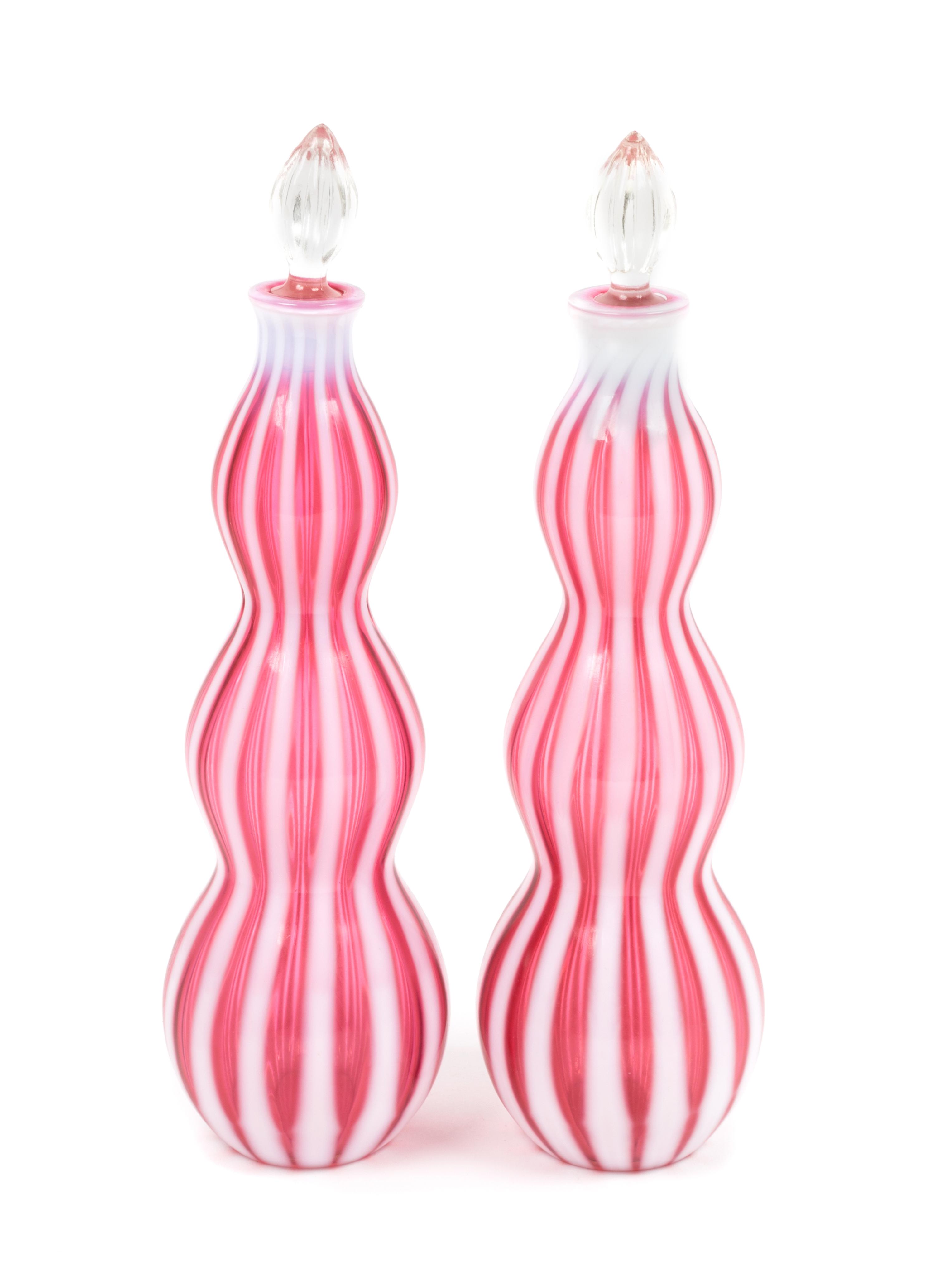 A Pair of Cranberry Rib Optic Bottles Height 14 1/4 inches.