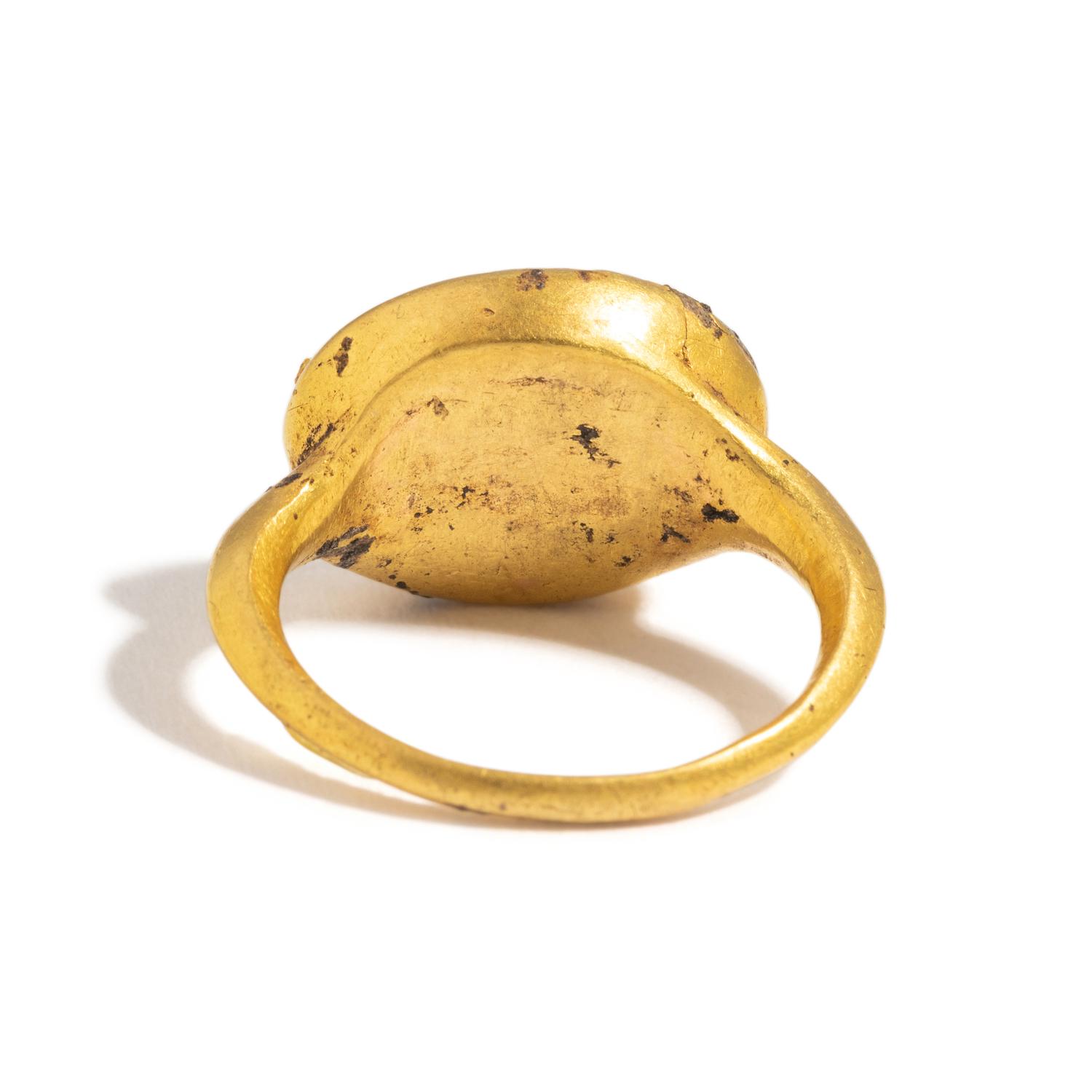 A Roman Gold and White Glass Finger Ring with a Male Portrait Head (Possibly a Young Hercules)