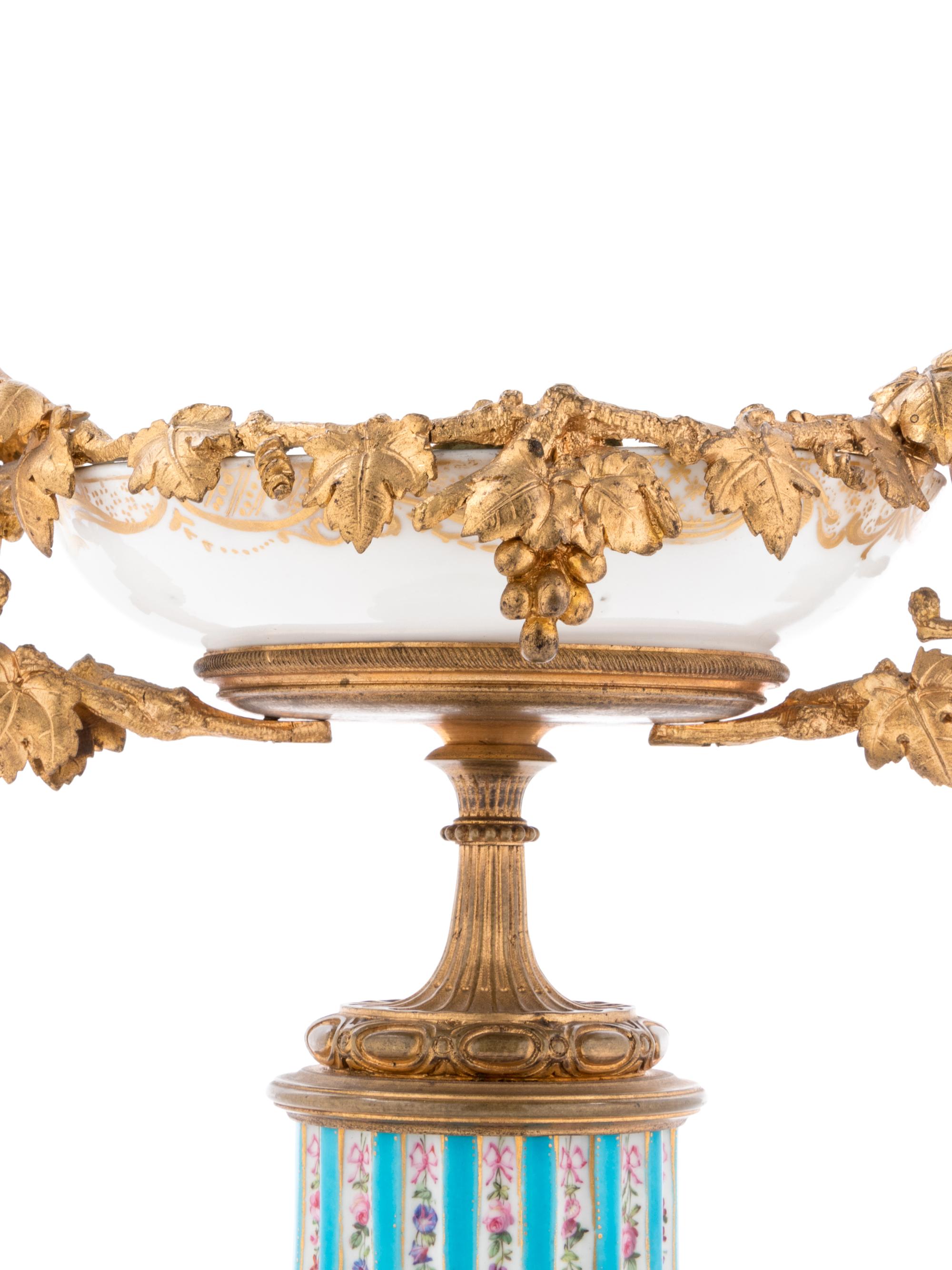 A Pair of Sèvres Style Gilt Bronze Mounted Painted and Parcel Gilt Porcelain Tazze