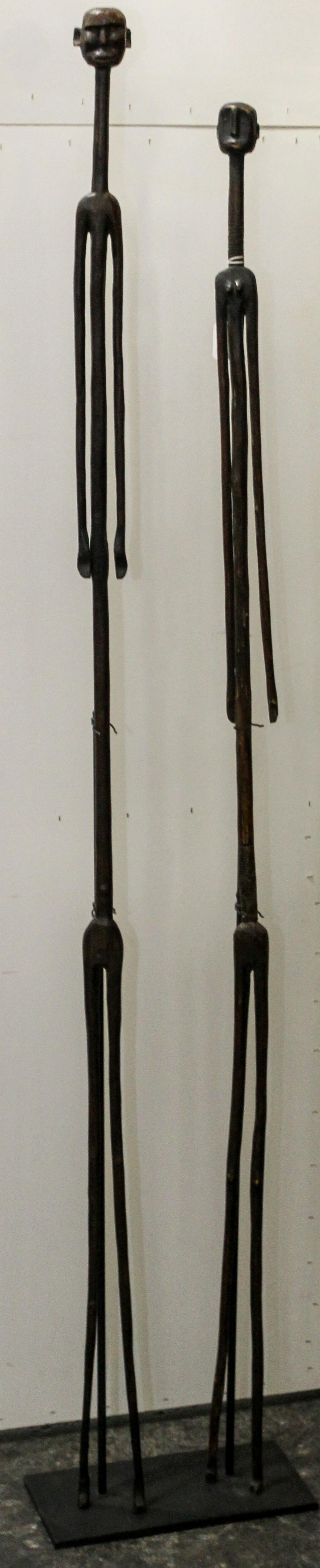 Two African Carved Wood Figures Height overall 64 inches.