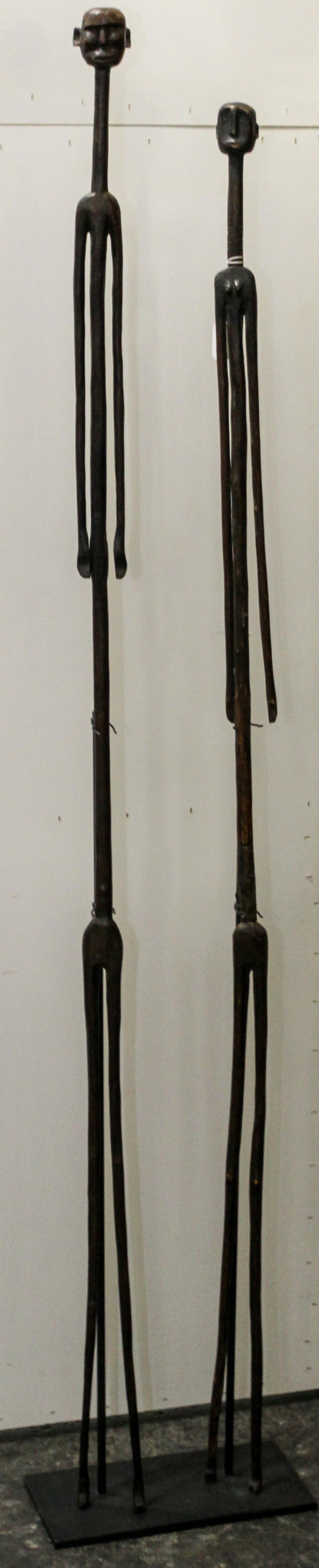 Two African Carved Wood Figures Height overall 64 inches.