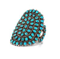 A Southwestern Silver and Turquoise Cluster Bracelet Length 5 7/8 x opening 1 3/8 x width 4 inches.