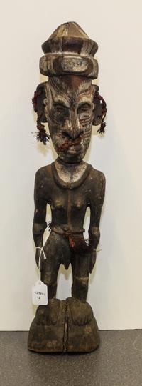 A New Guinea Tribal Polychrome and Cowry Shell Inset Carved Wood Figure Height 22 3/4 inches.