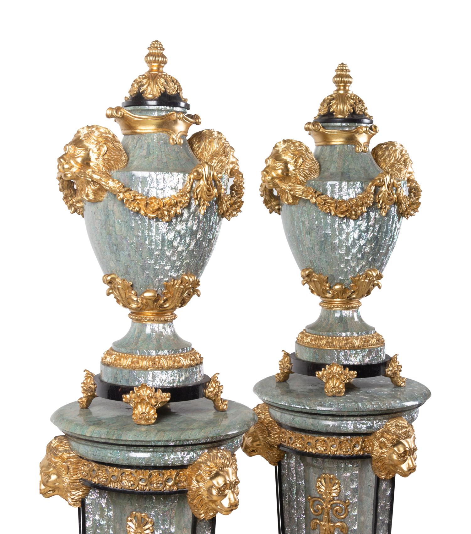 A Pair of Neoclassical Style Gilt Composite and Abalone Veneered Urns and Pedestals