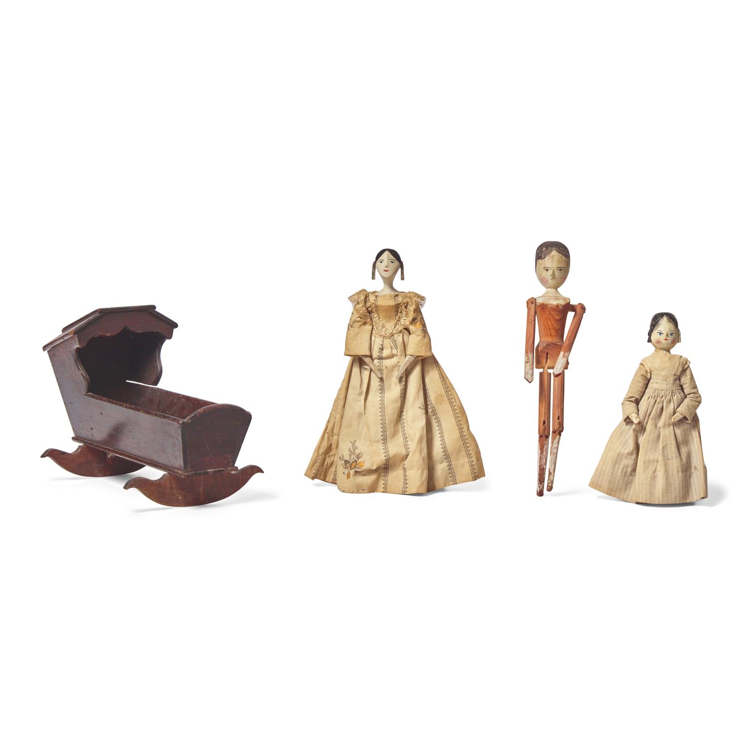 A Group of Three Peg Wooden Dolls and a Miniature Wood Cradle