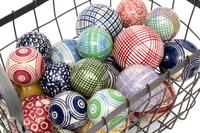 A Collection of English Polychrome Glazed Carpet Balls in a Wirework Basket