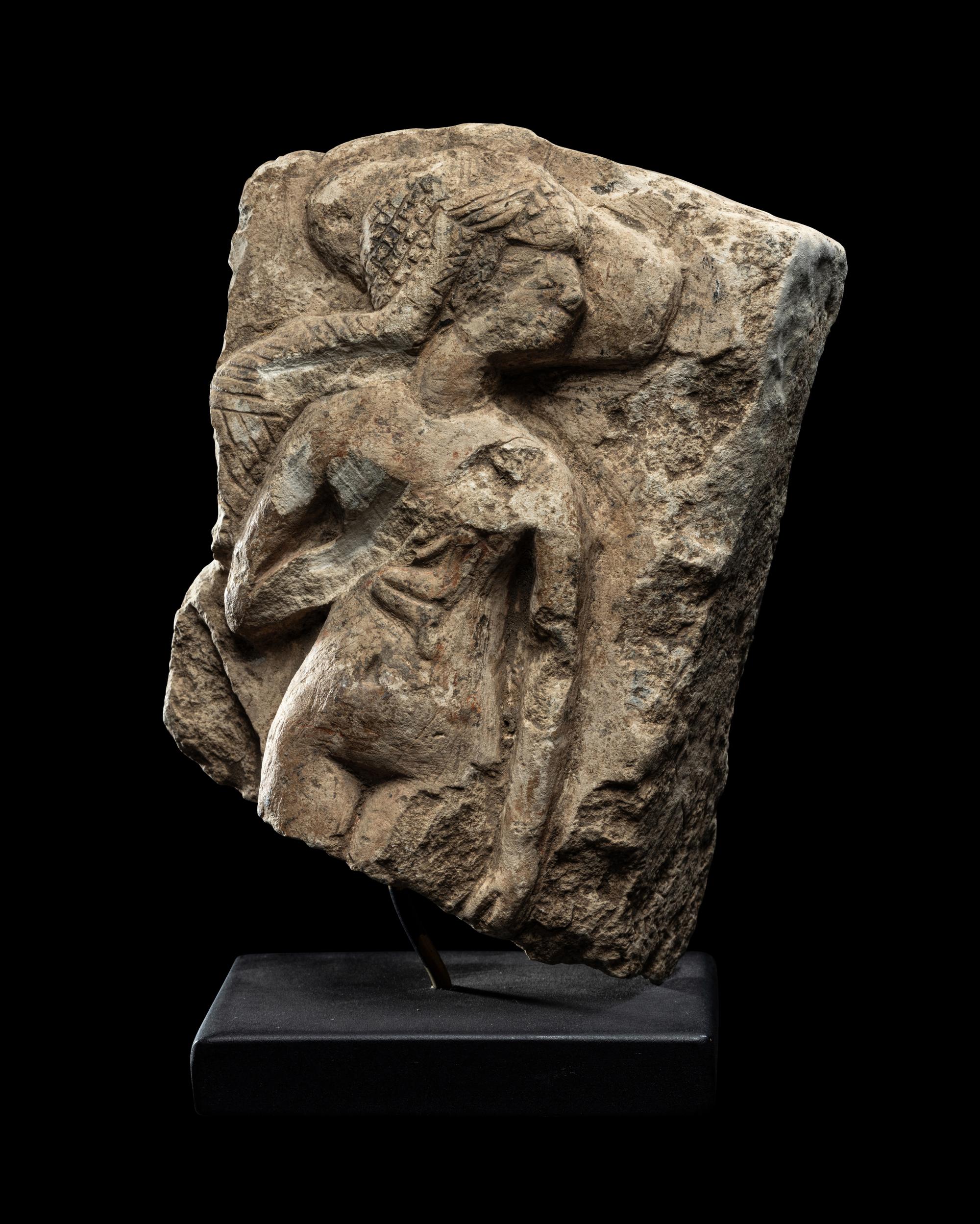 An Egyptian Limestone Fragment of a Mother Nursing her Child