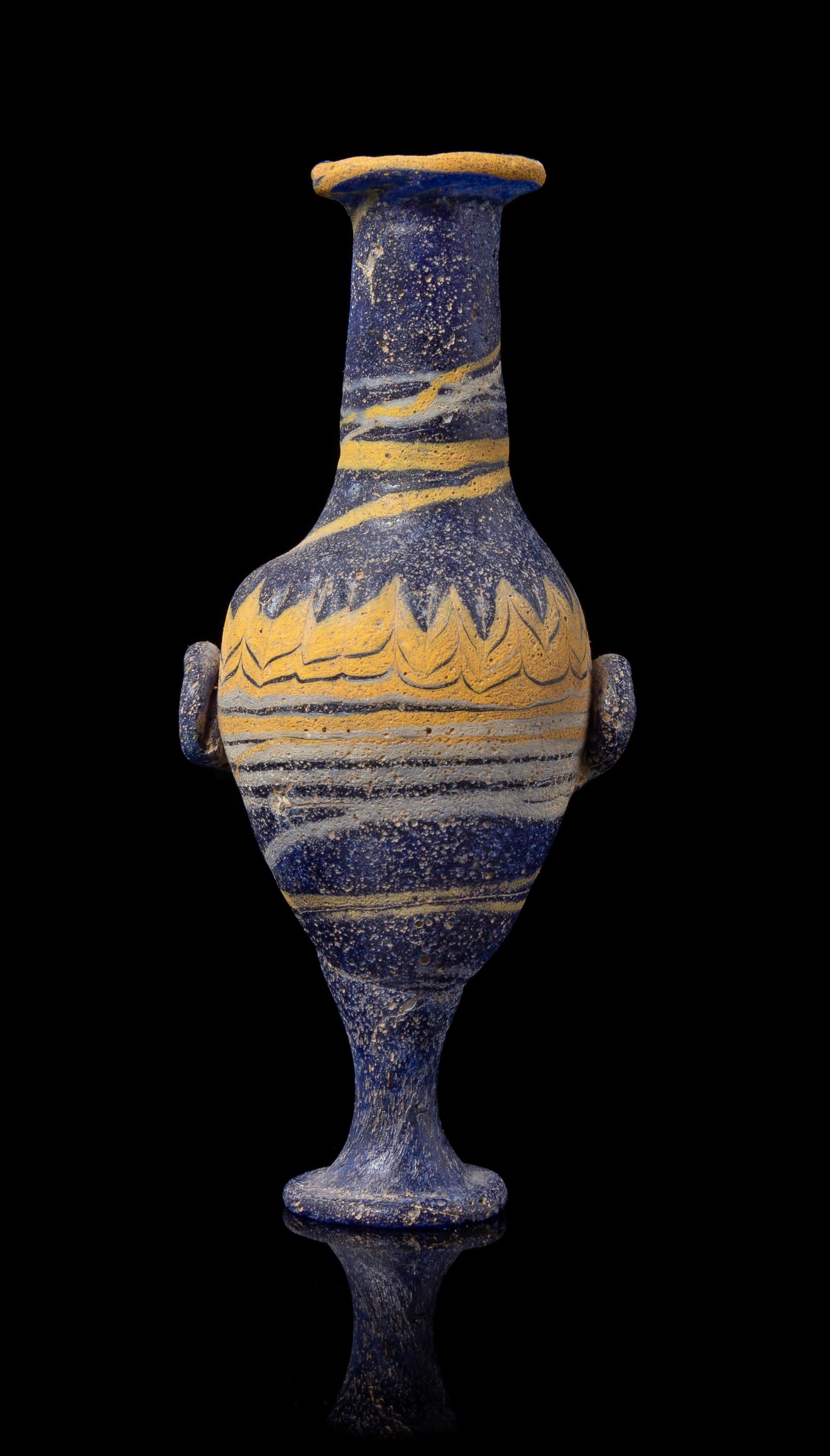 An Eastern Mediterranean Core-Formed Glass Unguentarium Height 4 3/4 inches. — CIRCA 4TH-3RD CENTURY B.C.E.