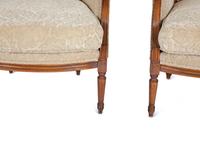 A Pair of Louis XVI Style Carved Walnut Bergères