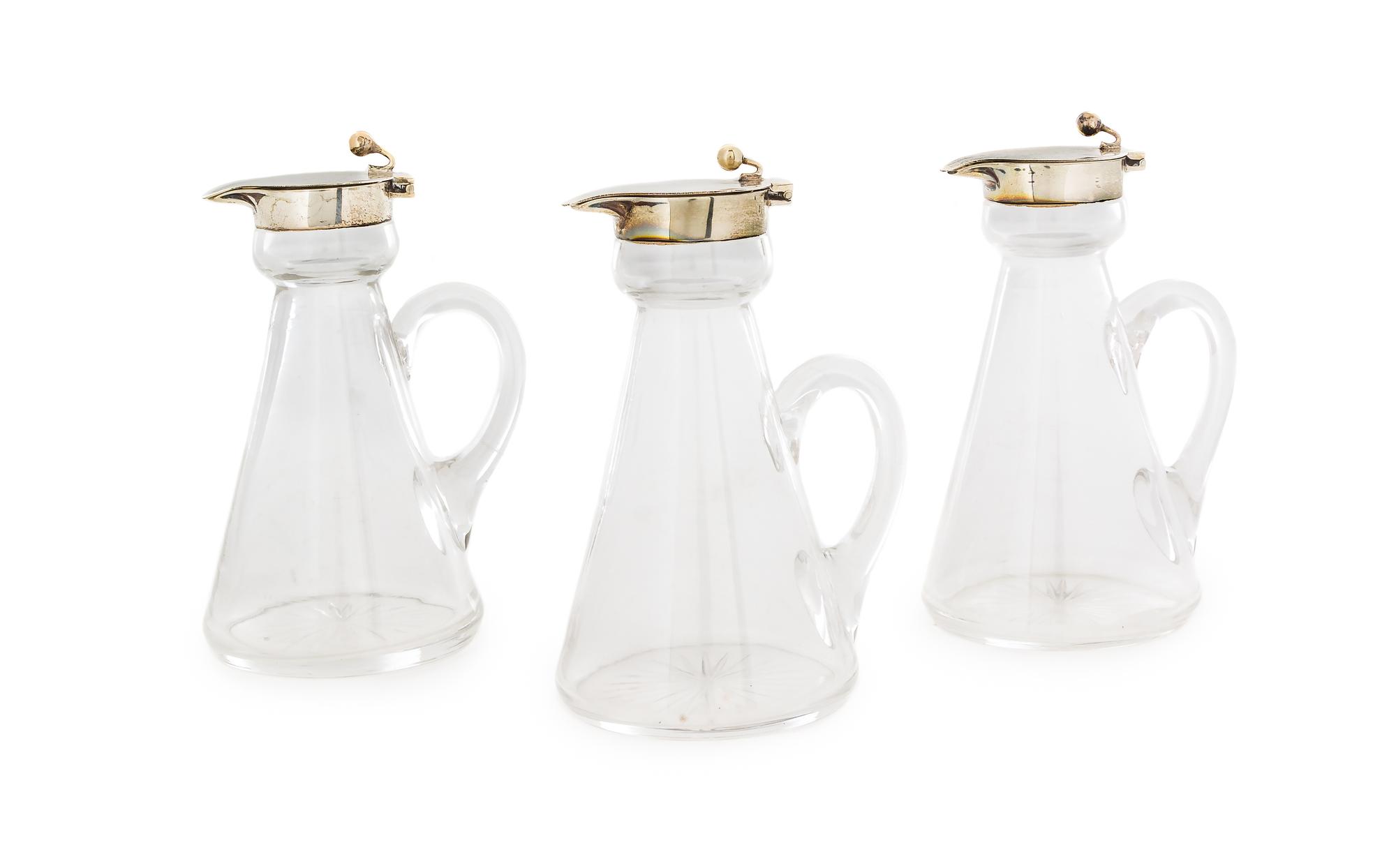 A Set of Three Edwardian Silver-Mounted Glass Cruets, H. B. Johnson & Co., Birmingham, 1910, the silver collar and spout with a globula