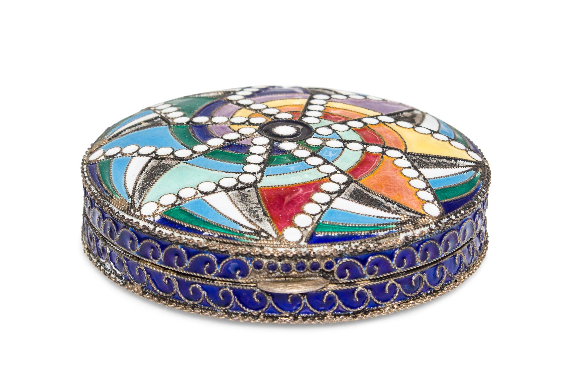 A Soviet Art Deco Enameled Slver Compact, St. Petersburg, 20th Century, of circular form with polychrome geometric decoration.