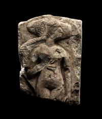An Egyptian Limestone Fragment of a Mother Nursing her Child