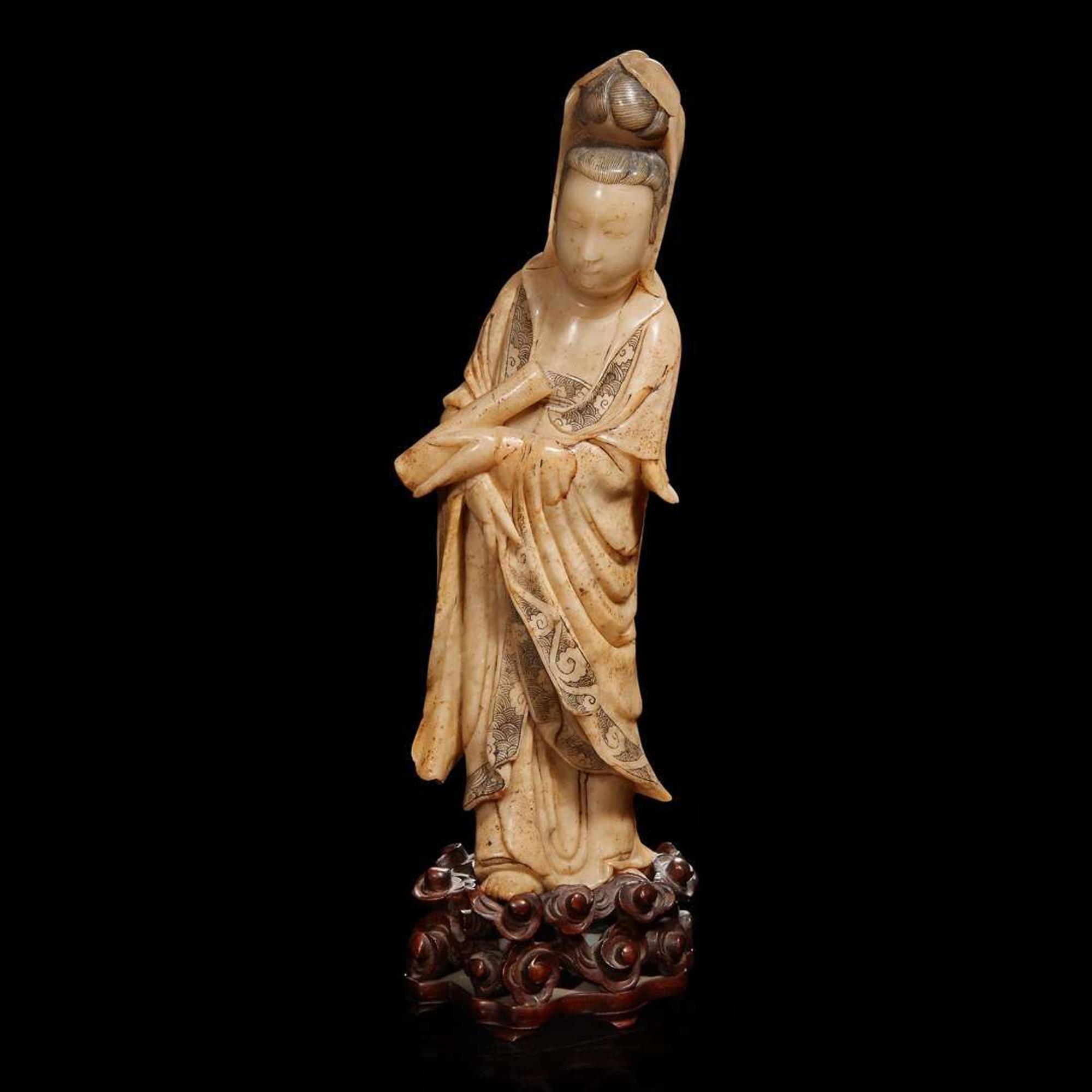 A Chinese carved beige soapstone figure of Guanyin and carved hardwood stand 壽山石雕觀音配木座 Late Qing dynasty/Republic period ?????