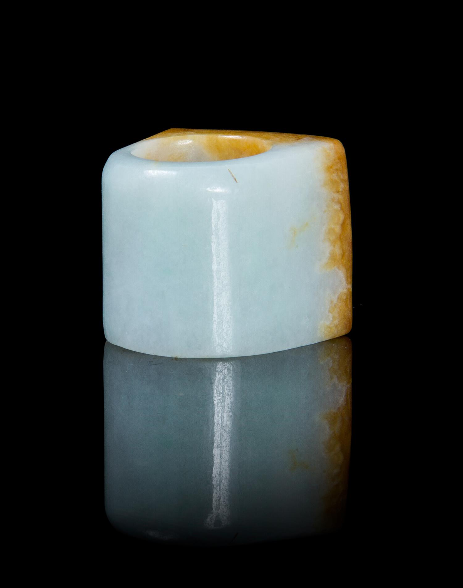 A Celadon and Russet Jade Archer's Ring Width overall 1 1/4 inches.
