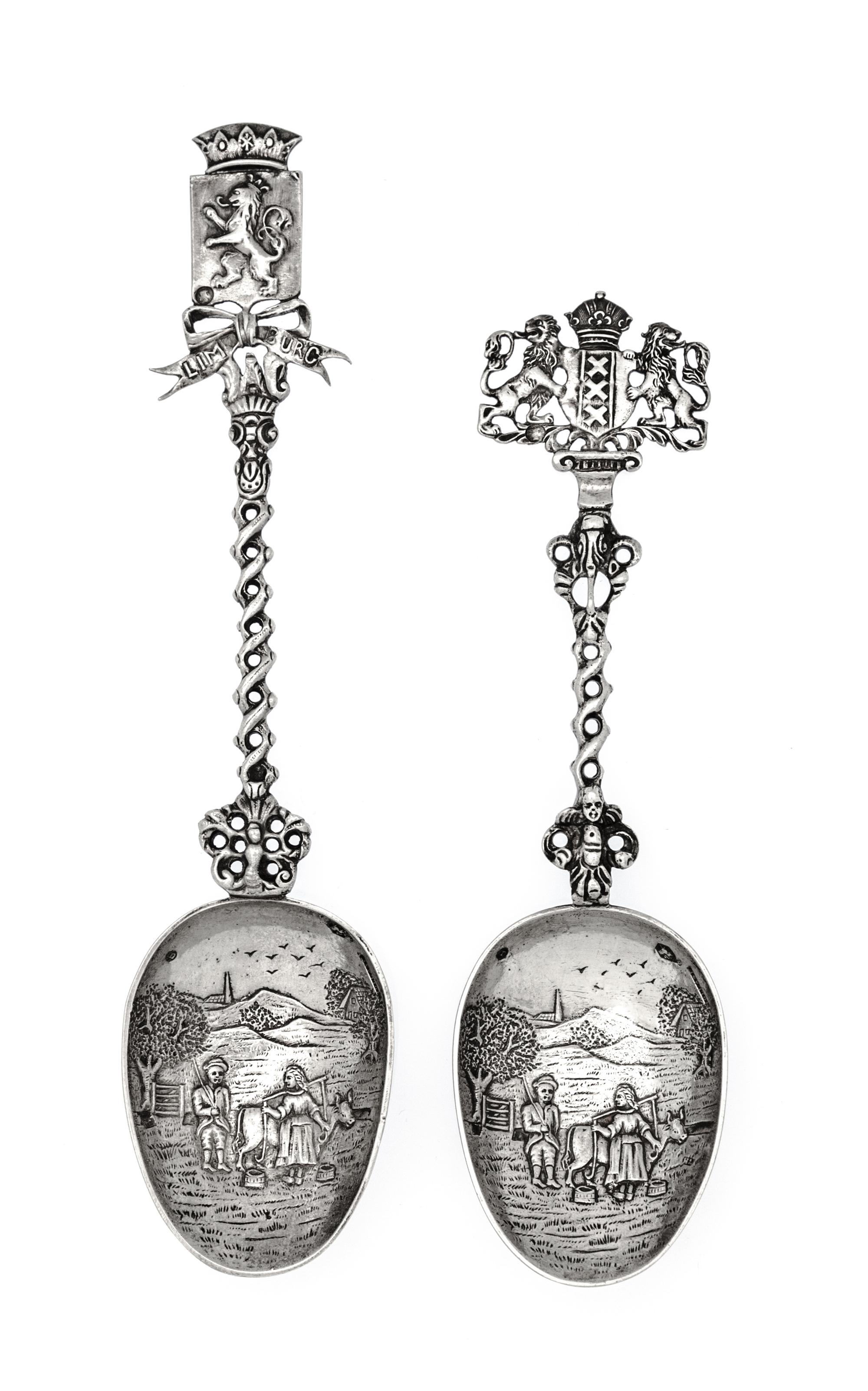 A Group of Two Dutch Silver Serving Spoons, Early 20th Century, each bowl decorated with a village scene with a twist stem surmounted b