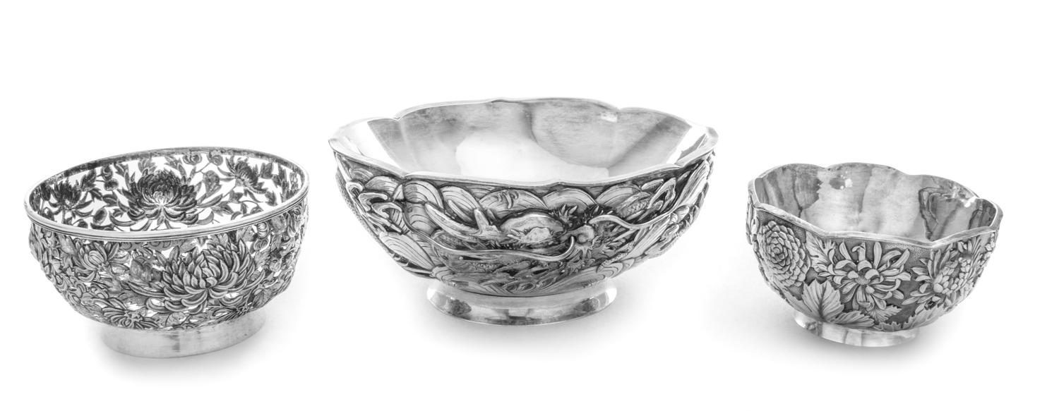 A Group of Three Chinese Silver Bowls, Various Makers, the largest bowl worked to show a writhing dragon among clouds, the two circular