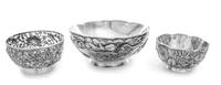 A Group of Three Chinese Silver Bowls, Various Makers, the largest bowl worked to show a writhing dragon among clouds, the two circular