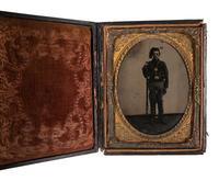 [CIVIL WAR]. Quarter plate tintype of a triple-armed private wearing a knitted smoking cap.