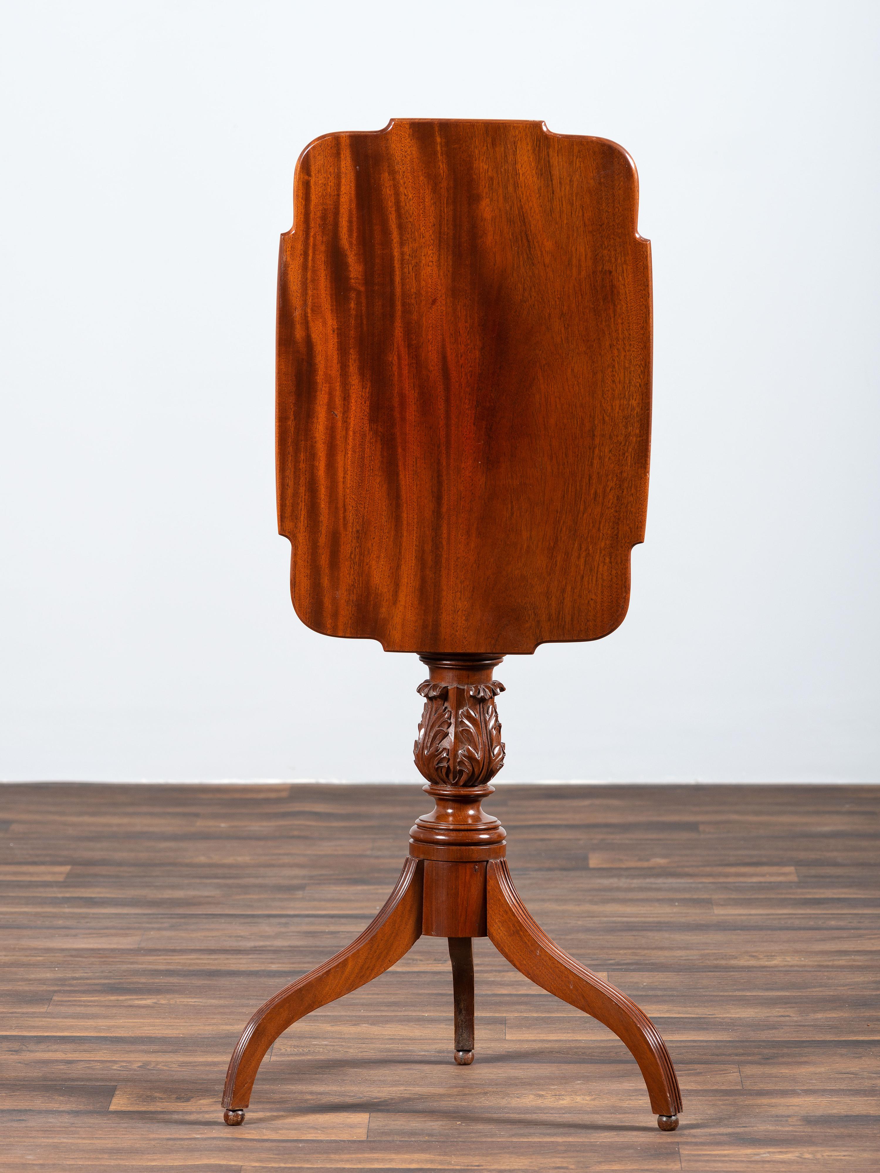 A Late Federal Carved and Figured Mahogany Shaped Top Candlestand
