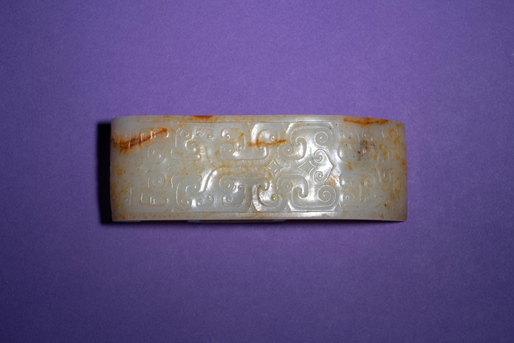 A Chinese White and Russet Jade Sword Slide, Jianzhi
