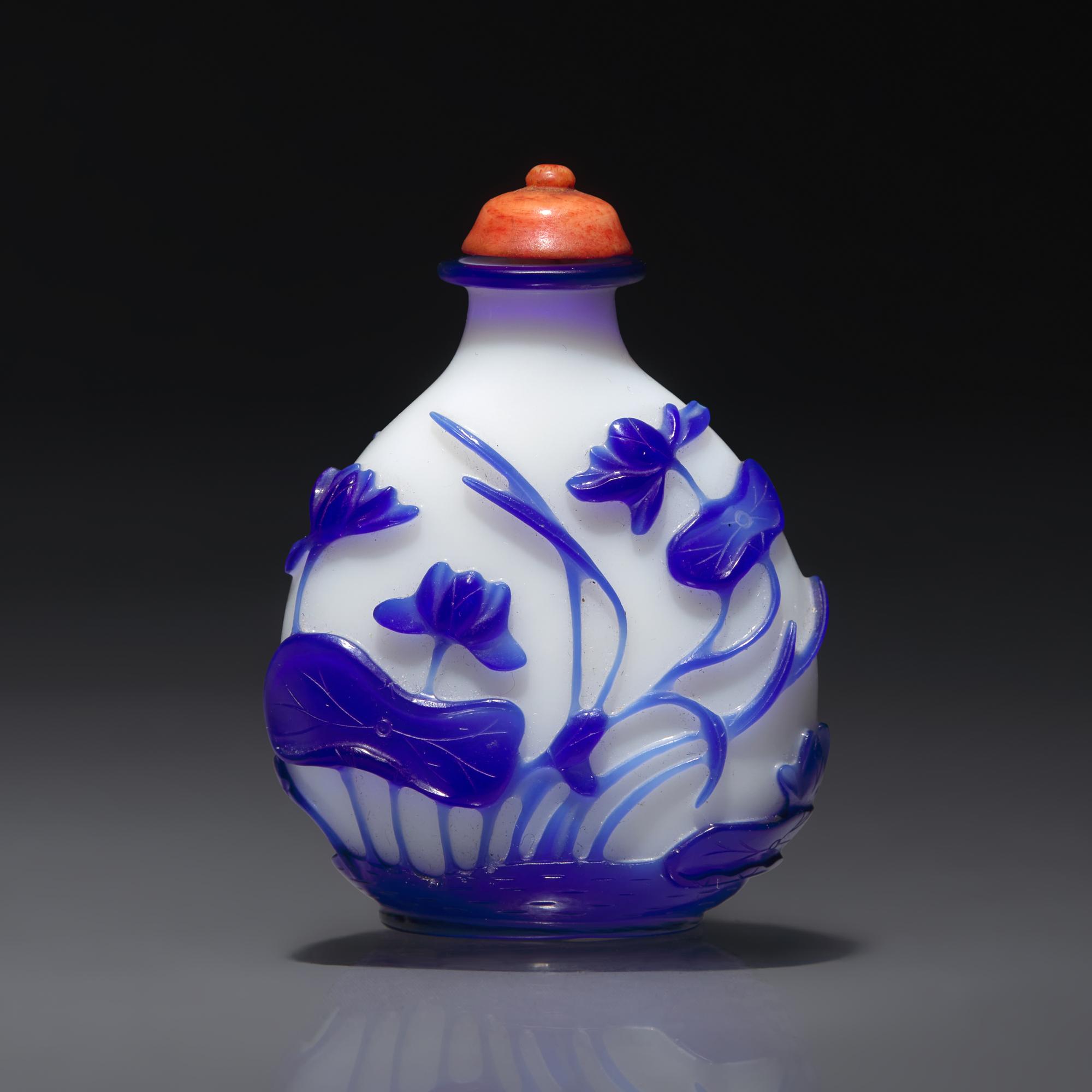 A Chinese Glass Overlay "Lotus" Snuff Bottle, Qing Dynasty, Circa 1750-1795 — 1750-1795年 涅白地套寶石藍料荷花紋鼻煙壺