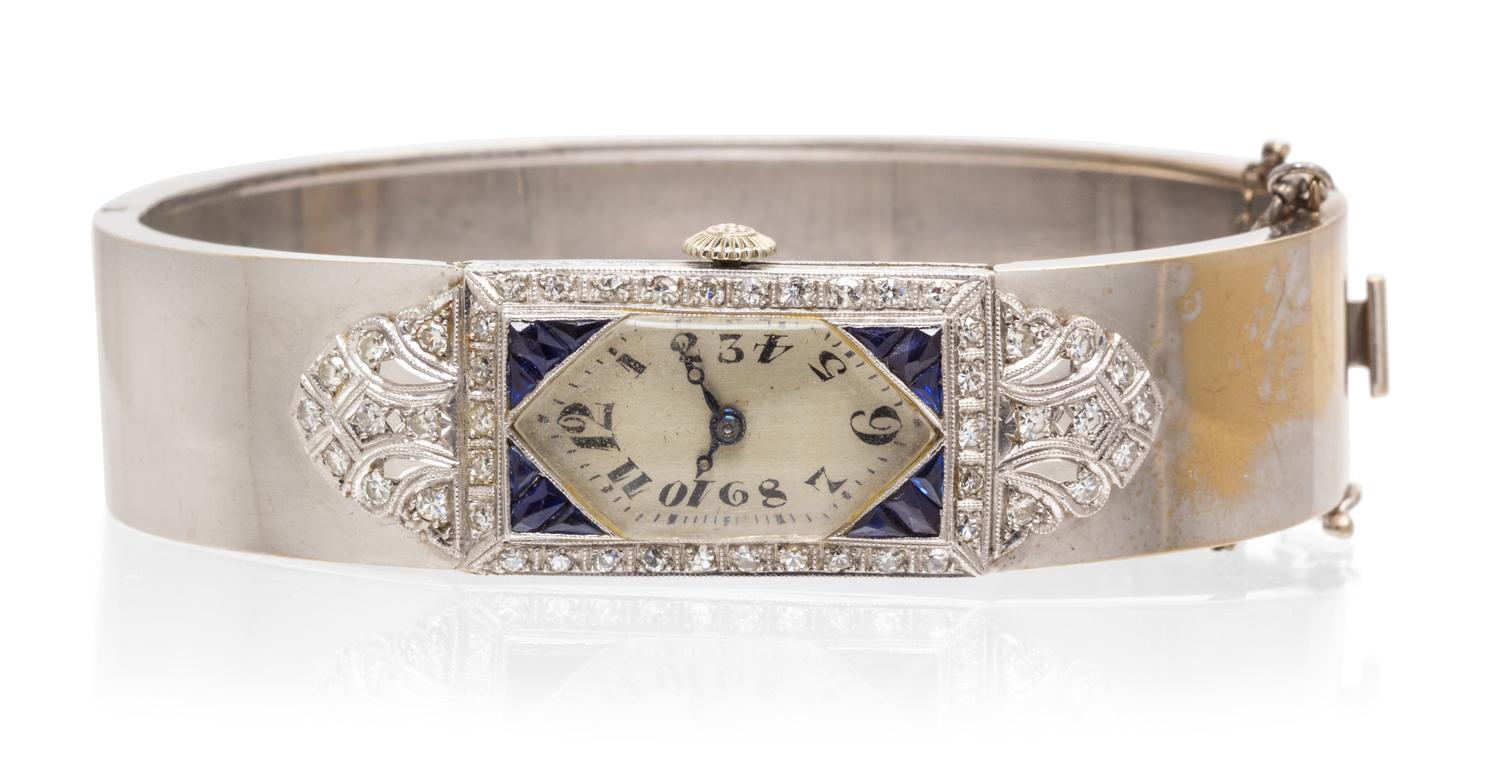 A Platinum, Rhodium Plated Gold, Diamond and Synthetic Sapphire Bangle Bracelet Wristwatch, 29.00 dwts.