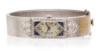 A Platinum, Rhodium Plated Gold, Diamond and Synthetic Sapphire Bangle Bracelet Wristwatch, 29.00 dwts.