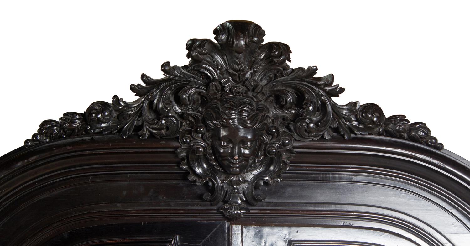 An Italian Rococo Revival Carved Ebonized Bookcase