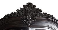 An Italian Rococo Revival Carved Ebonized Bookcase
