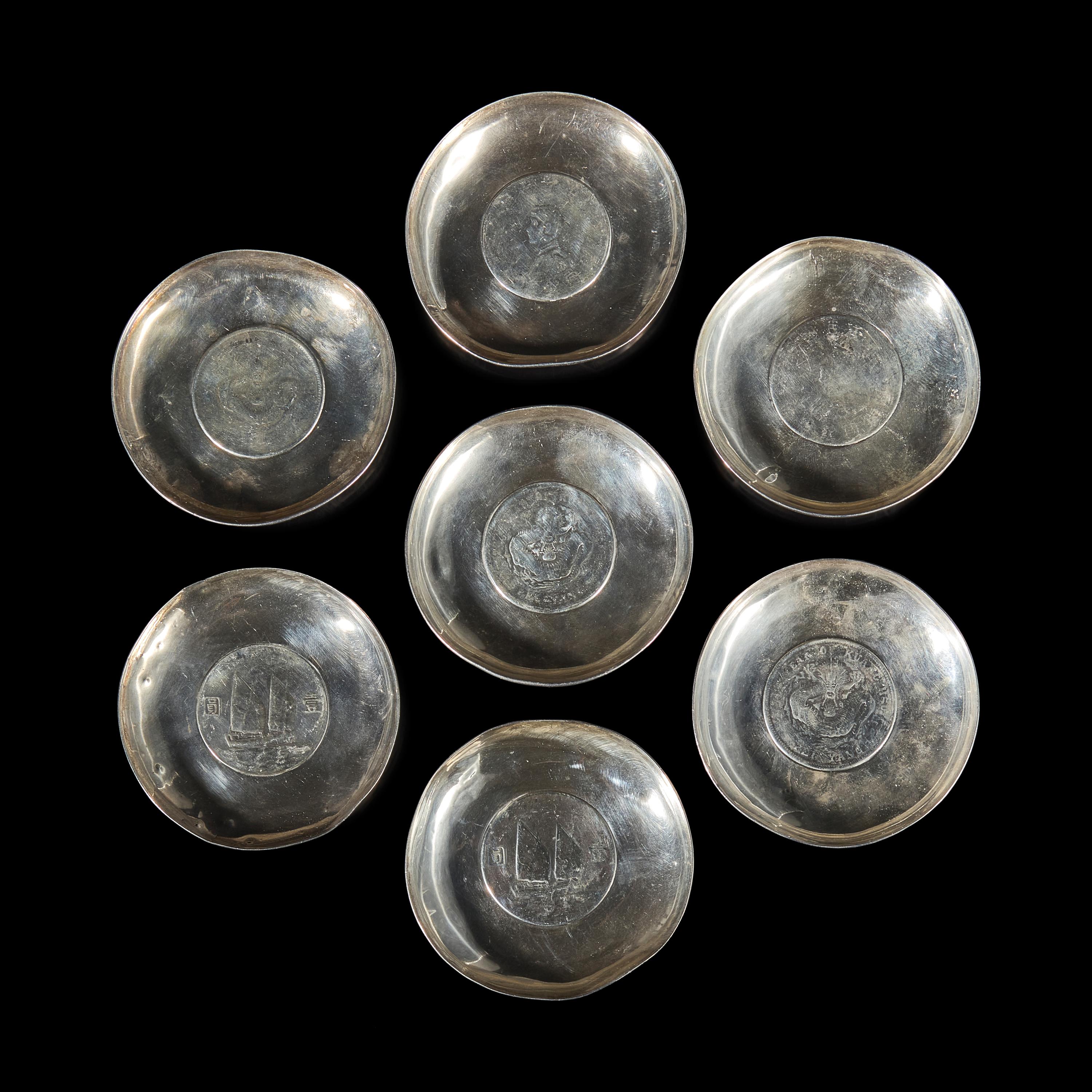 A Group of Seven Chinese Silver Coin-Mounted Small Dishes, 20th Century — 近代 銀嵌機制幣小碟一組七件